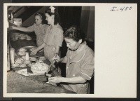 [recto] Mrs. Kiye Iyoya is shown at work with two Caucasian workers in the kitchen of the Elms Hotel in Excelsior ...