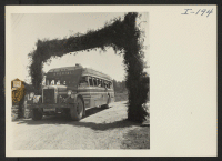 [recto] Closing of the Jerome Center, Denson, Arkansas. A bus load of Jerome residents are seen passing under the Welcome approach as they enter the Rohwer Center to take up their new residence. ;  Photographer: Iwasaki, Hikaru ;  Denson, Arkansas.