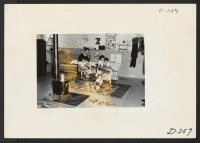 [recto] An evacuee family spends a quiet evening in their barracks. The decoration of this apartment is quite typical and shows the home made furniture, shelves, bookcases and other furniture. ;  Photographer: Stewart, Francis ;  Newell, California.