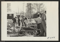 [recto] Workers preparing drainage ditches in front of the Block 7 mess hall. ;  Photographer: Parker, Tom ;  Denson, Arkansas.