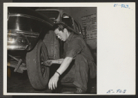 [recto] Jim Canda, a former west coast garage operator who spent several months in the Granada Relocation Center, inspects brake drums on his present job as night manager of the Master Service Garage in Denver. ;  Photographer: Parker, Tom ;  Denver, Colorado