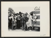 [recto] Members of farm families board evacuation buses. Evacuees of Japanese ancestry will be housed in War Relocation Authority centers for the duration. ;  Photographer: Lange, Dorothea ;  Centerville, California.