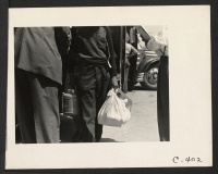 [recto] Stockton, Calif.--These evacuees of Japanese ancestry are bringing fresh food with them to this Assembly Center. ;  Photographer: Lange, Dorothea ;  Stockton, California.