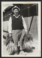 [recto] Project farmer with carrots. ;  Photographer: Cook, John D. ;  Newell, California.