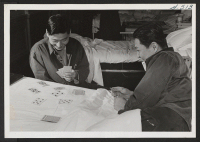 [recto] Pvts. Kazuto Yoshioka and Wallace Hisamoto have a game of cards in the ward at Walter Reed Hospital. Yoshioka lost his right arm below the elbow and Hisamoto his left leg, both in action with the 100th Battalion in Italy. ;  Photographer: Van Tassel, Gr