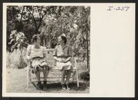 [recto] Mrs. Uneyo Ishimoto and her daughter, Carol, in the garden of the home of Mr. and Mrs. Edgar Seeler, Cambridge, Massachusetts. ;  Photographer: Iwasaki, Hikaru ;  Cambridge, Massachusetts.