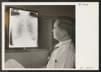 [recto] Placing an X-ray in a viewing box for study is Dr. Harold Kushi, M.D., formerly of Los Angeles, California. At ...