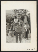 [recto] This youngster is awaiting evacuation bus. Evacuees of Japanese ancestry will be housed in War Relocation Authority centers for the duration. ;  Photographer: Lange, Dorothea ;  Centerville, California.