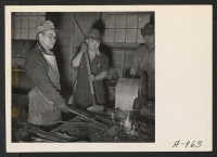 [recto] Evacuee blacksmiths do all the blacksmith work necessary in the garage, at this relocation center. ;  Photographer: Stewart, Francis ;  Newell, California.