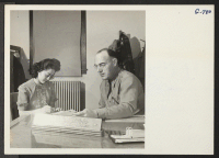 [recto] Miss Rose Yokomizo, a native of Scottsbluff, Nebraska, takes dictation from Major William A. Kutzke, post engineer, whose secretary she is. Until recently she did secretarial work for the War Relocation Authority office at Scottsbluff, Nebraska. ;  Phot