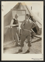 [recto] Lt. Harvey H. Severson (right) of military police, and Dr. Charles W. Anderson of Bishop discuss procedure at this War Relocation Authority center for evacuees of Japanese ancestry. ;  Photographer: Albers, Clem ;  Manzanar, California.
