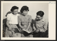 [recto] Aiko Nomiyama (left) from Granada, Sada Akazawa (center) from Manzanar, and Carl Kondo, (right) from Manzanar are seen going over ...