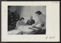 [recto] The Superintendent of Schools, A. G. Thompson, on a busy morning in his office. (L to R) Miye Magota, stenographer; A. G. Thompson, Superintendent of Schools; Ida Mae Clark, Secretary to the Sup't. ;  Photographer: Parker, Tom ;  Denson, Arkansas.