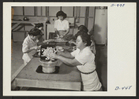 [recto] Students preparing carrots for dehydration. Carrots are peeled, sliced cross-wise, washed, and then steamed before the drying process is started. ;  Photographer: Stewart, Francis ;  Rivers, Arizona.