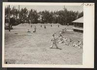 [recto] Young evacuees of Japanese descent play baseball on their day of arrival at this assembly center. They will be transferred later to a War Relocation Authority center. ;  Photographer: Albers, Clem ;  Salinas, California.