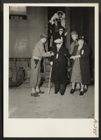[recto] Evacuees of Japanese ancestry arrive here by train and await buses for Manzanar, now a War Relocation Authority center. ;  Photographer: Albers, Clem ;  Lone Pine, California.