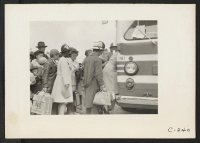 [recto] The bus has just arrived and these farm families of Japanese ancestry are being kept intact enroute to the Assembly Center. ;  Photographer: Lange, Dorothea ;  Centerville, California.