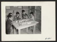 [recto] Nursery school children with model barracks. ;  Photographer: Stewart, Francis ;  Newell, California.