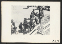 [recto] Turlock, Calif.--These evacuees of Japanese ancestry awaiting their turn for medical examination before being assigned to their places in the barracks, after their arrival at this Assembly center. ;  Photographer: Lange, Dorothea ;  Turlock, Californi