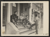 [recto] (Buchanan Street.) High school boys of Japanese ancestry in the Japanese quarter on a busy Saturday afternoon, watching preparations for evacuation which is due in a few days. ;  Photographer: Lange, Dorothea ;  San Francisco, California.