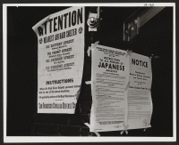 [recto] On a brick wall beside air raid shelter poster, exclusion orders were posted at First and Front Streets directing removal ...