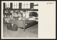 [recto] Henry Suenaga (reading newspaper) from Manzanar, and Ben Nishiyama from Poston, relaxing in a section of one of the men's ...