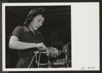 [recto] Mrs. Masako Toyama, a former Californian, who was evacuated from the west coast and spent several months in a relocation center, at work on the bench of a defense plant, rewinding truck armatures at the Thompson Auto Supply Company of Denver. ;  Photogr