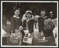 [recto] Three sisters, all high school students, awaiting evacuation bus. Evacuees of Japanese ancestry will be housed in War Relocation Authority centers for the duration. ;  Hayward, California.
