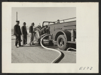 [recto] Fire drill and, under the direction of a Caucasian Fire Chief, the volunteer fire staff learns to use the center fire fighting equipment. ;  Photographer: Parker, Tom ;  Amache, Colorado.
