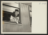 [recto] Closing of the Jerome Center, Denson, Arkansas. An attractive Miss, aboard the train for Gila River, smiles as she calls to her friends who assembled at the train to say Aloha. ;  Photographer: Iwasaki, Hikaru ;  Denson, Arkansas.