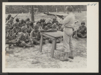 [recto] Lieutenant Watt instructs a class in the mechanism of the Ml rifle. The 442nd combat team at Camp Shelby is ...
