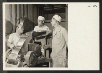 [recto] Mr. George Naganuma (middle) and Mr. Satokichi Sashihara (right) are shown here at work in the Tablet Coating Room under ...