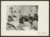 [recto] High school class in commercial arts, using a student as a model for sketching fashion figures. Art classes in the Junior High School and adult sections carry a crowded quota of students. ;  Photographer: Parker, Tom ;  Amache, Colorado.