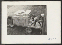 [recto] Evacuees loading trucks with supplies for transportation to the warehouses at this relocation center. ;  Photographer: Parker, Tom ;  McGehee, Arkansas.