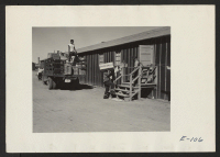 [recto] Crates of personal belongings shipped from Assembly Centers being delivered to permanent duration residents in this relocation center. ;  Photographer: Parker, Tom ;  Heart Mountain, Wyoming.