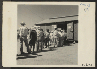 [recto] Manzanar, Calif.--Evacuees of Japanese ancestry at this War Relocation Authority center line up at warehouse No. 26 for their allotment ...