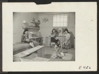 [recto] Two adult women and a small girl occupy this barracks room at the Amache Center. All the furniture, shelves and the dressing table were made by the girls from scrap lumber picked up from the contractors' scrap pile. ;  Photographer: Parker, Tom ;  Ama