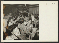 [recto] Barn dance given in Block 12. No music was available so evacuees of Japanese descent sang Pop goes the Weasel and clapped hands while dancing the Virginia Reel. Evacuees of Japanese ancestry are spending the duration at War Relocation Authority centers.