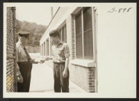 [recto] Saburo Iwana of Manzanar checks in at the gate of the American Brass Company in Waterbury, Connecticut, where he is ...