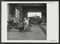 [recto] View in the machine shop, where tracks, tractors, automobiles, and other machines are repaired. ;  Photographer: Stewart, Francis ;  Poston, Arizona.