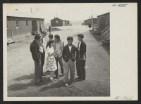 [recto] Heart Mountain high school campus scene. Classes are housed in tar paper-covered barracks-style buildings originally designed as living quarters for the evacuees. ;  Photographer: Hosokawa, Bill ;  Heart Mountain, Wyoming.