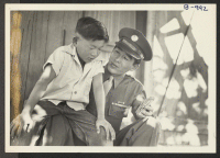 [recto] Sgt . Kazuo Komoto, veteran of Guadalcanal and New Georgia, shows his medal, the Purple Heart, to his younger brother, Susumu, while visiting his parents at the Gila River Relocation Center near Phoenix, Arizona. ;  Rivers, Arizona.