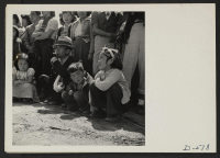 [recto] Manzanar, Calif.--Evacuees of Japanese ancestry watching Memorial Day services. Evacuee Boy Scouts took a leading part in the ceremonies held at this War Relocation Authority center. ;  Photographer: Stewart, Francis ;  Manzanar, California.