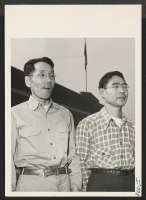 [recto] Ihei Hatanaka and Paul Koga, Isseis relocated in Kansas City, Missouri, are shown in front of the plant where they ...