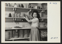 [recto] Mary Sakai in the pantry store room, showing the storage method. ;  Photographer: Stewart, Francis ;  Rivers, Arizona.