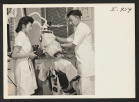 [recto] Miss Marie Watkins, the Executive Secretary of the Fresno International Institute, is getting an X-Ray of her teeth taken by ...