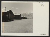[recto] Manzanar, Calif.--Street scene looking west between barrack blocks at this War Relocation Authority center for evacuees of Japanese ancestry. ;  Photographer: Lange, Dorothea ;  Manzanar, California.