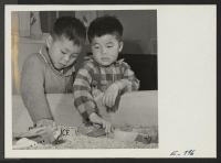[recto] Two young pre-school students play in the sand box at the Jerome Center grade school. Left, Sei Asaki; right, Horace Mochizuki. ;  Photographer: Parker, Tom ;  Denson, Arkansas.