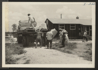 [recto] Closing of the Jerome Center, Denson, Arkansas. A crew is shown gathering mattresses from the evacuated barracks and piling them on a truck to be taken to the center's warehouse for storage. ;  Photographer: Iwasaki, Hikaru ;  Denson, Arkansas.