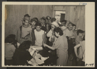 [recto] Manzanar, Calif.--Newcomers waiting their turn to be vaccinated at this War Relocation Authority center for evacuees of Japanese ancestry. A personal history is kept of each case in the hospital of which this is a temporary building. ;  Photographer: Al